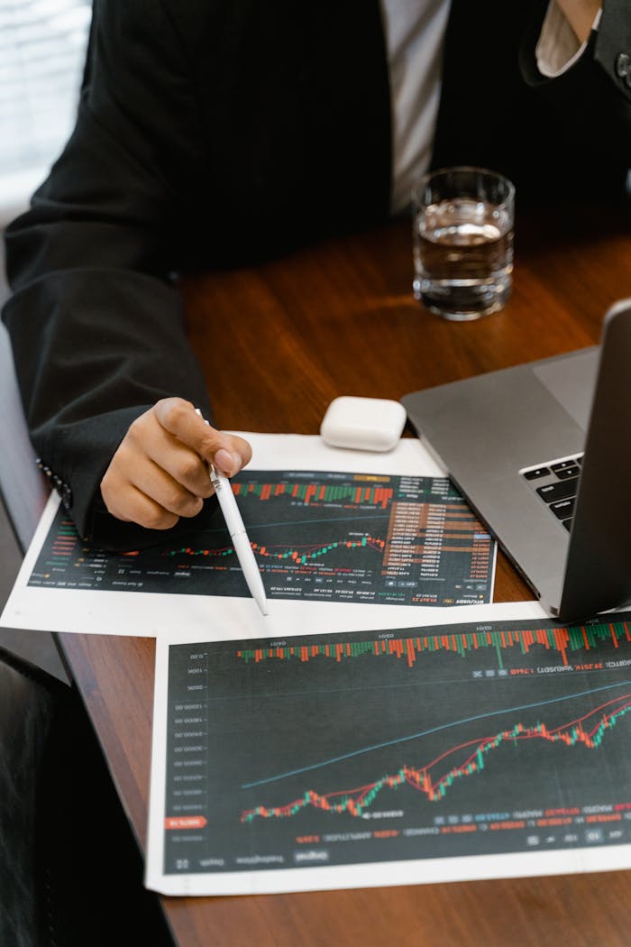 why-choose-us Close-up of a business analyst reviewing printed financial graphs and charts at an office desk.